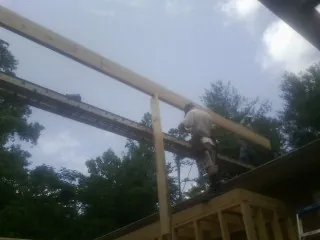 Carpenter setting a ridge beam over a new addition frame — Ice Dam Removal by Roofing Brothers in Bowdon