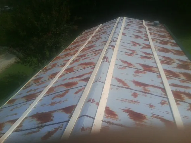 Rusted metal roof panels with new wood purlins before replacement — Storm Damage Roof Repair in Bowdon by Roofing Brothers