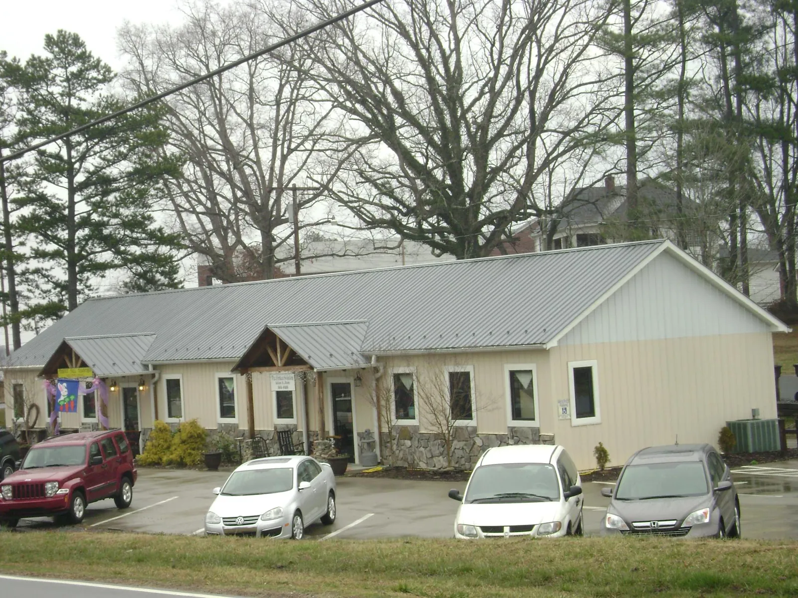 Gray metal roof with timber entry brackets on a small commercial building in Bowdon