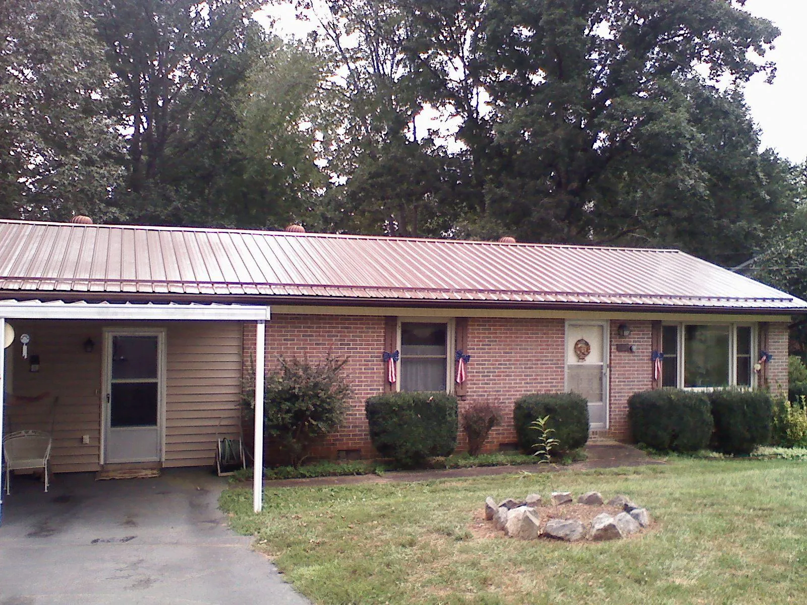 Bronze metal roof and carport on a brick ranch home — Roof Repair work by our crew in Bowdon