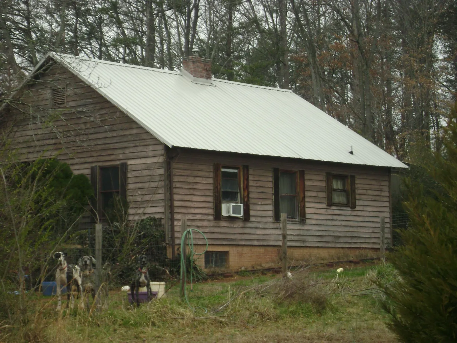 White metal roof on an old wood sided farmhouse, from a Metal Roof Installation job in Bowdon